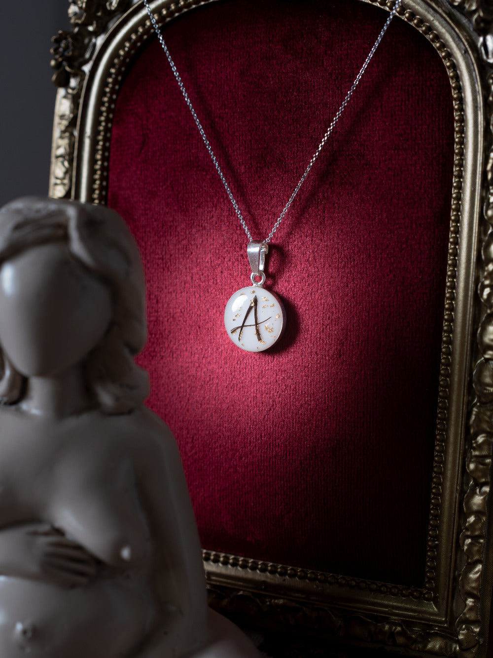 bijou au lait maternel rond avec lettre en mèche de cheveux